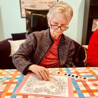 a senior resident of pacifica senior living mission villa paints a coloring book image