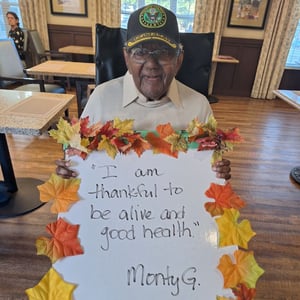 senior male resident shares thanksgiving sign saying he is thankful for good health