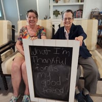 residents of pacifica senior living peoria with a sign saying thankful for their friendship
