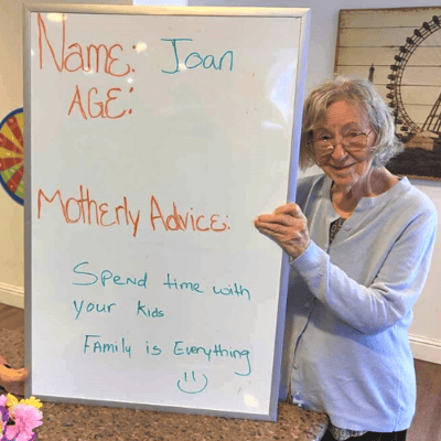 pacifica senior living resident shows her mothers day advice sign