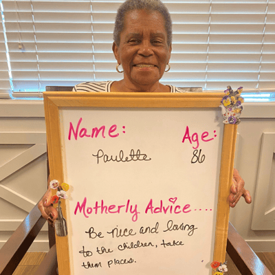 Paulette of riverside holds a sign with her mothers day advice