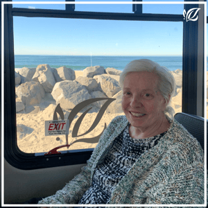 a pacifica senior living resident poses on a bus trip to the beach