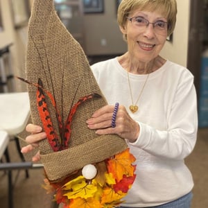 pacifica resident shows off her gnome craft made from leaves and burlap