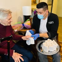 a senior resident of pacifica senior living mission villa enjoys a relaxing hand massage from an employee