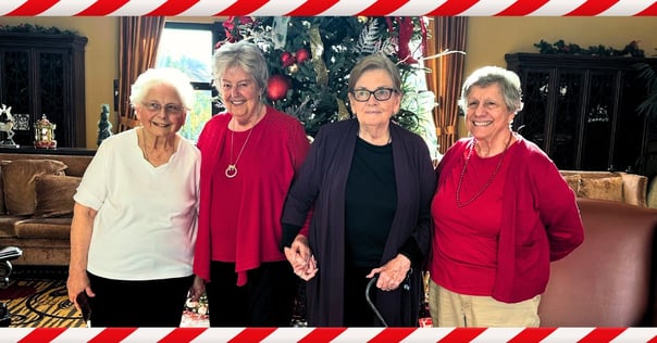 senior residents from Pacifica Senior Living Oceanside pose in front of the Christmas tree together