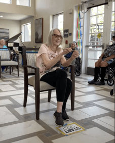 a resident at pacifica senior living rancho penasqitos tries a game of rubber band archery