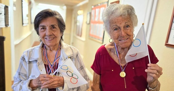 two older women wave olympic flags pacifica senior living residents