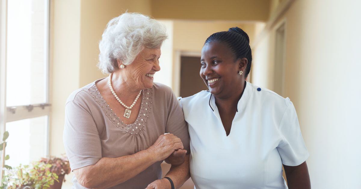 an older woman and nurse walk arm in arm assisted living blog header